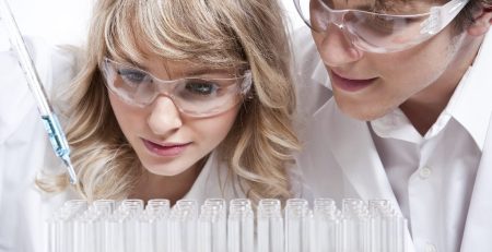 Female and male researchers examining test tubes