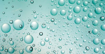 Beads of water on a green glass surface