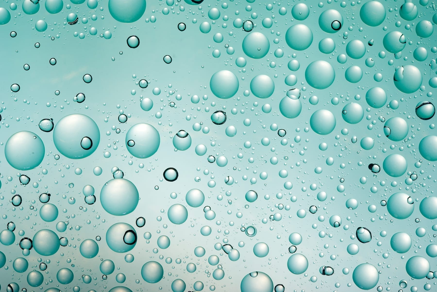 Beads of water on a green glass surface