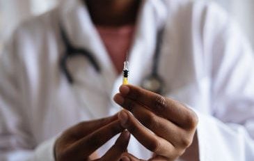 Doctor holding a hypodermic needle preparing to give a shot